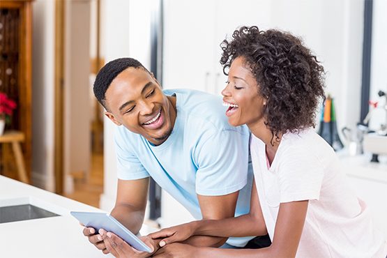 happy young couple uses insurance calculator on tablet